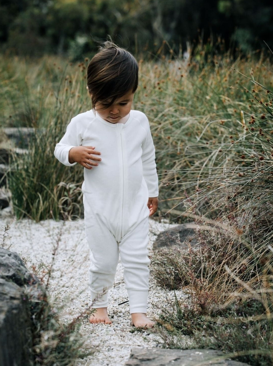 Baby in romper ,walking in the garden path